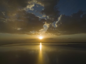 A calm sunset over a lake with golden coloured sky and clouds, aerial view, salt lake, Tuz Gölü,