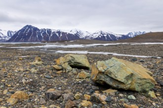 Melting glacier, copper-bearing stones, water, mountain range, Cooper Camp, Spitsbergen, Svalbard