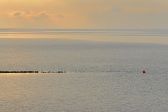 Evening mood at the Wadden Sea, stone groyne with red buoy, North Sea, Norddeich, Lower Saxony,