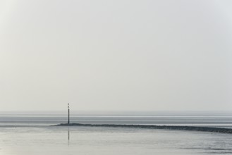 North Sea coast, cloudy winter day, Wadden Sea at low tide, stone groyne with sea mark, North Sea,
