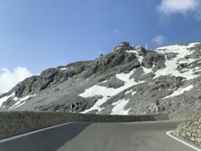 View in front of a narrow bend above the tree line in front of the Stelvio Alpine Pass road to the