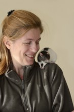 Woman with coloured rat (Rattus novegicus forma domestica) on her shoulder, North Rhine-Westphalia,