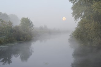 The river Lippe with full moon and morning fog, North Rhine-Westphalia, Germany