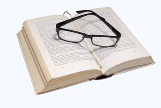 Reading glasses and book on a white background