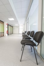 Bright corridor with chairs in the waiting area and modern glass walls, Care Connect, vaccination