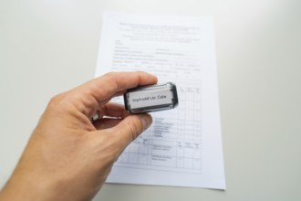 Close-up of a stamp in a hand over a form, Care Connect, vaccination kiosk for refugees, Calw,