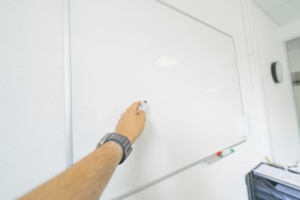A hand writes with a pen on a white board, Care Connect, vaccination kiosk for refugees, Calw,