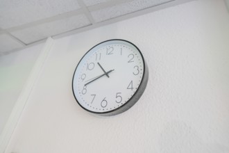 Plain white wall clock with black hands on the wall, Care Connect, vaccination kiosk for refugees,