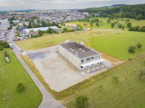 Aerial view shows a building under construction in a rural area, green roof, house construction,