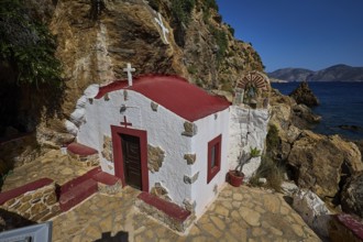 Legend, crab, shell fisherman, chapel on the rocky coast with red roof and sea view, under a clear