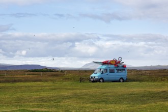 Motorhome with sports equipment on the roof, campsite in Selvogur, south coast, Iceland