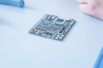 Close-up of a circuit board on a table in focus, blurred background