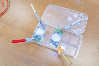 Electrical experiment with wires and a liquid in trays in the laboratory, Battery Research, Nagold,