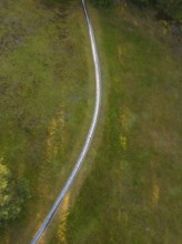 Close-up of a curved path across a green meadow, Retro Freizeitpark Poppeltal Riesenrutschbahn,