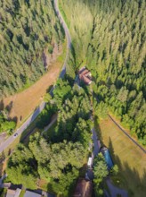 Aerial view of a winding road through a wooded area with neighbouring buildings, Retro Freizeitpark