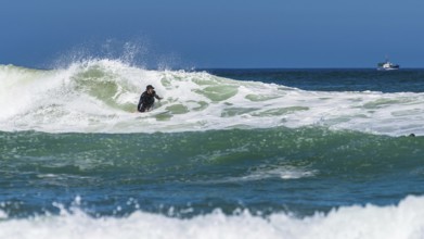 Surfer riding a wave on Contis beach, Saint Julien en Born, Saint-Julien-en-Born, Landes, France