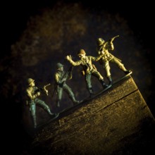A group of toy soldiers are captured in motion as they navigate a steep incline, showcasing
