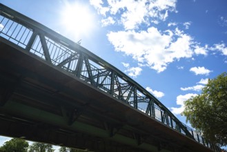 Steel bridge against the sunny sky in a dramatic perspective, Iron Bridge in Neunkirchen, Lower