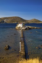 Long view of the chapel on the island with long jetty, surrounded by sea and blue landscape,