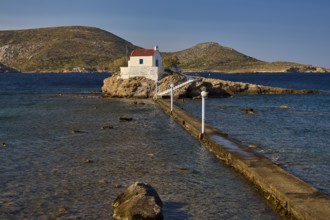 White chapel with red roof on rocky island, accessible via a long footbridge, chapel, church, Agios