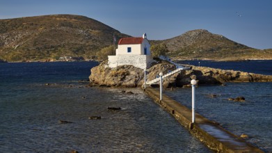 Chapel on an island, framed by blue sky and mountains, with access via a footbridge, Chapel,
