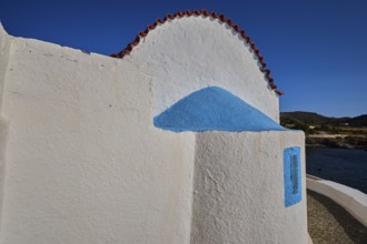 Close-up of a white church wall with blue accents and red roof, chapel, church, Agios Isidoros,