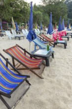 Abandoned deckchairs and parasol after sunset at Charlie Beach, Koh Mook Island, Andaman Sea,