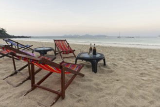Abandoned deckchairs and parasol after sunset at Charlie Beach, Koh Mook Island, Andaman Sea,