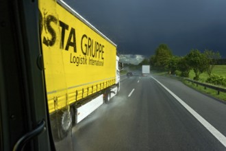 Overtaking manoeuvre of articulated lorry, lorry overtaking in thunderstorm, heavy rain, poor