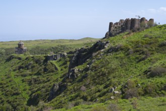 Ruins of an old fortress on a green hill in rural surroundings, Amberd Fortress and Mother of God