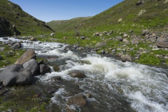 A rushing river surrounded by rocks and green hills, Amberd Gorge, Aragazotn Province, Armenia