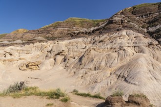 Sunlight bathes the otherworldly terrain of drumheller, alberta, showcasing the unique hoodoo