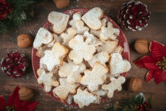 Plate full of cookies with Christmas decorations and walnuts