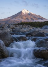 Mount Taranaki in the evening at sunset, in the foreground Stony River (Hangatahua River) . Egmont