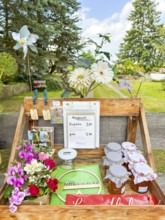 Table for sale of postcards and marmalade with floral decorations and treasury of trust,