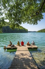 People on a boat dock and in turquoise blue water, Schmaler Luzin Lake, Feldberg Lake District,