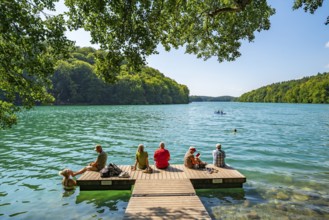People on a boat dock and in turquoise blue water, Schmaler Luzin Lake, Feldberg Lake District,