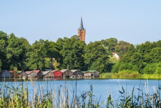 View across the Haussee to the town church and colorful boathouses on stilts, Feldberg, Feldberg