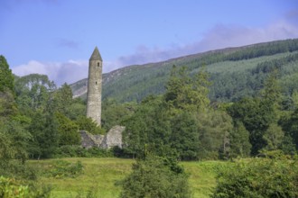 Round tower surrounded by forest, Glendalough, Wicklow Mountains National Park, Brockagh, County