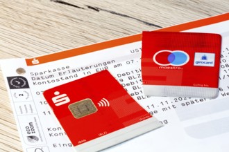 Cut-up savings bank card on account statements (symbolic image)