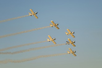 Stunt aerobatic planes performing stunts in blue sky with smoke trail. Concept of teamwork,