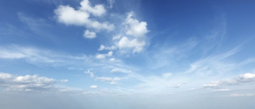 A tranquil sky filled with soft clouds under bright blue hues creates a peaceful daytime scene,