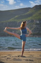 Woman practicing Utthita Hasta Padangusthasana Extended Hand-to-Big-Toe Pose on a serene beach