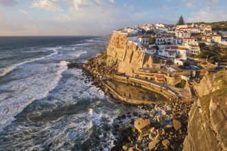 Charming Azenhas do Mar, a picturesque fishing village perched on cliffs. The sun sets over the