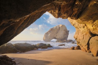 At Praia da Santa Cruz, Penedo do Guincho stands majestically as waves crash into the sandy beach