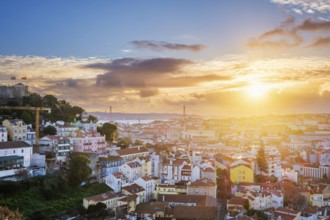 Breathtaking sunset over Lisbon, highlighting the city's rooftops, Carmo Convent ruins, and the
