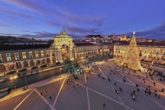 Praca do Comercio in Lisbon features a large Christmas tree and festive lights during evening