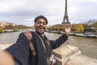 Young male tourist smiling and gesturing with open hand, capturing a memorable selfie while