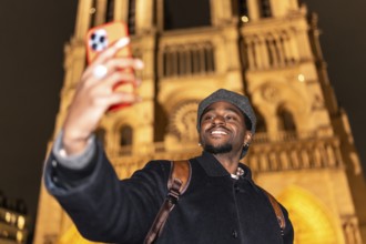 Young man smiling and taking a selfie with a smartphone, capturing a memorable moment during a
