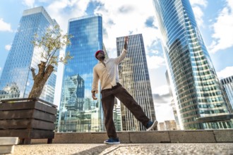 Happy black man celebrating joy and freedom with a dynamic dance on a urban plaza, surrounded by